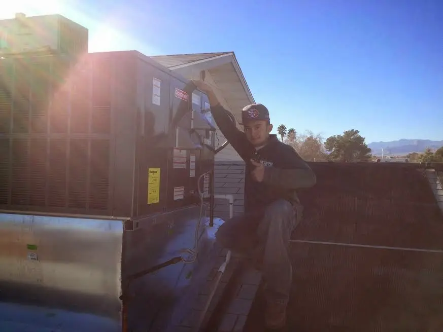 HVAC technician performing Heat Pump Repair on a rooftop unit in Scio